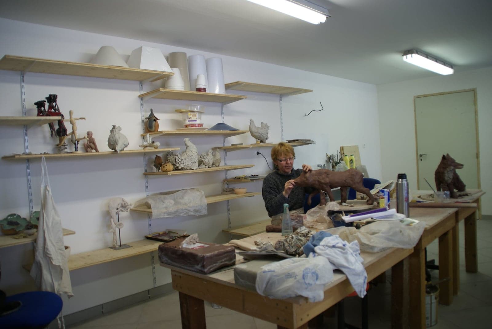 L'atelier de Martine Cassar : étagères de pièces en cours, tables de travail et sculptures en attente