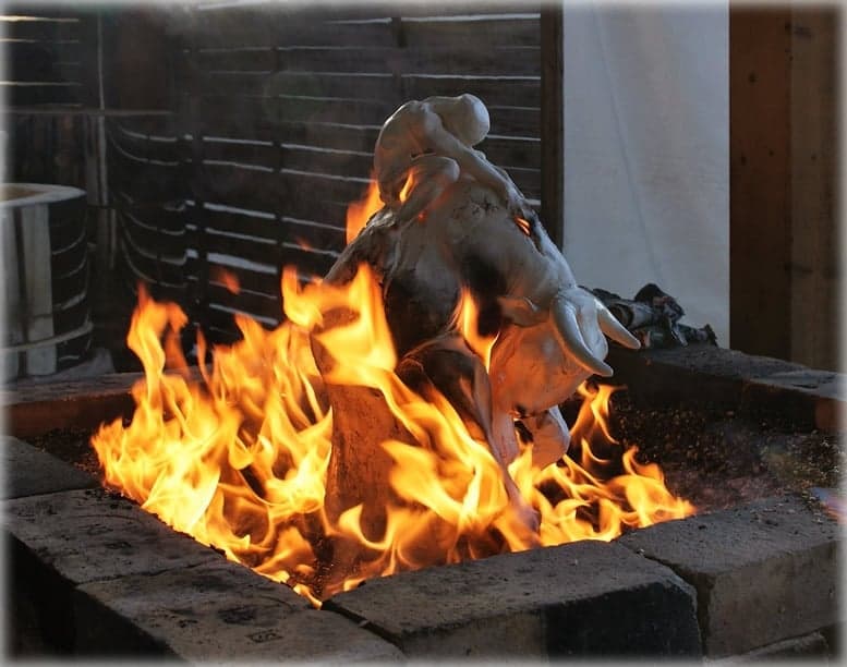 Sculpture en céramique au milieu des flammes lors d'une cuisson raku en extérieur
