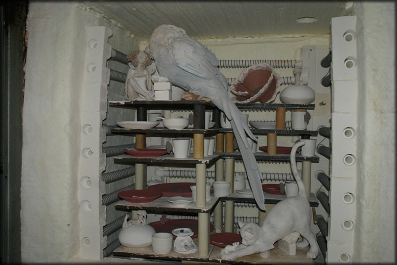 Intérieur d'un four céramique chargé de pièces sur plusieurs étagères